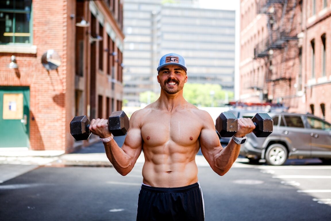 Bron Volney training with dumbbells outside BronCore Fitness