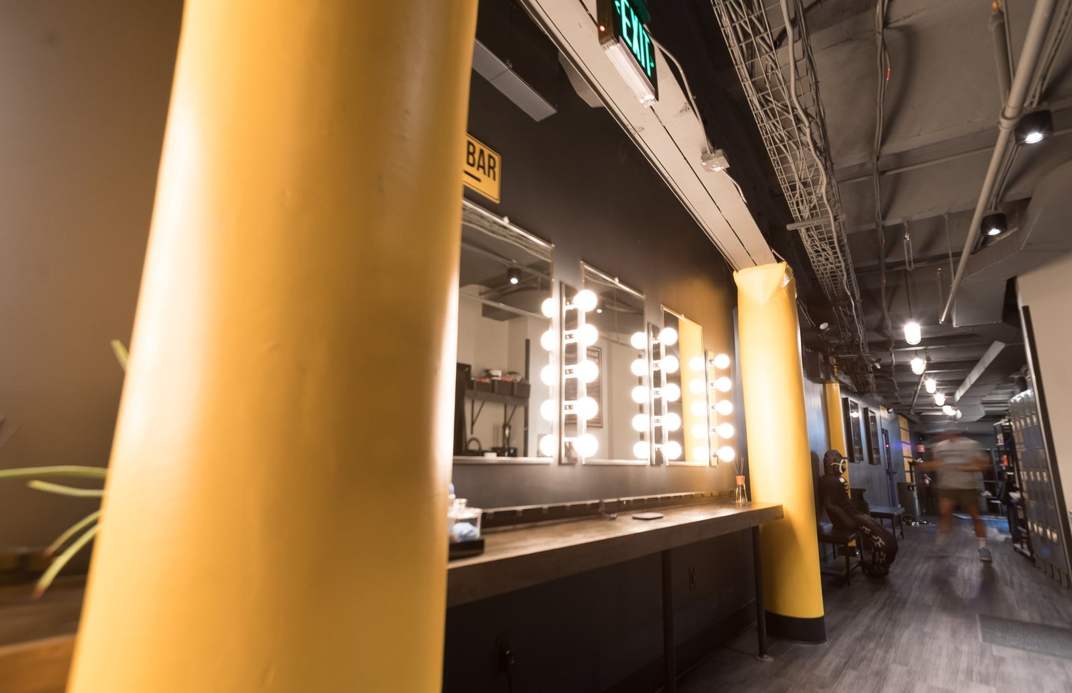 The mirrored entrance corridor with BronCore Fitness yellow columns
