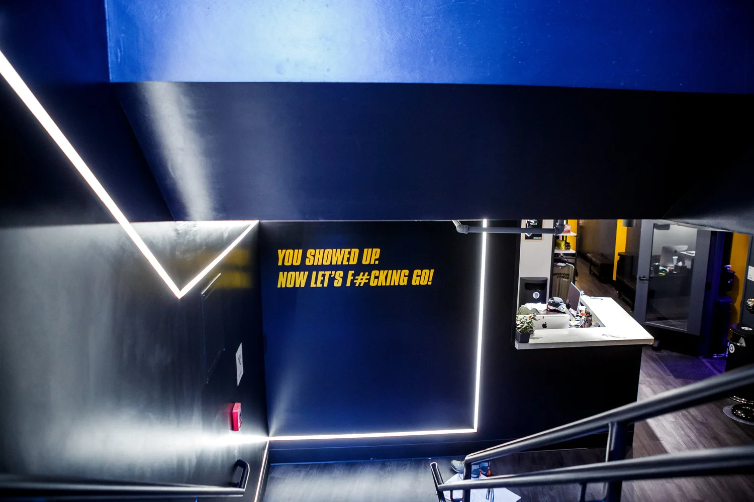 The stairway and neon signage leading into the BronCore Fitness studio