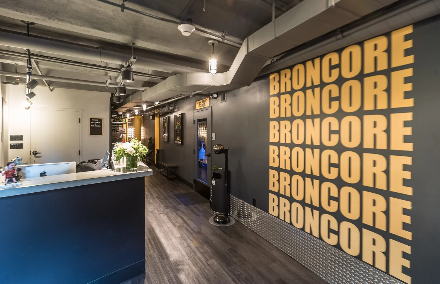 The BronCore Fitness reception and front desk with the BRONCORE wall at 42 Court St.